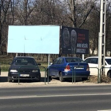 Foto: Vēbera vizītes laikā Ungārijā aizmālē Junkeru un Sorosu nomelnojošus plakātus