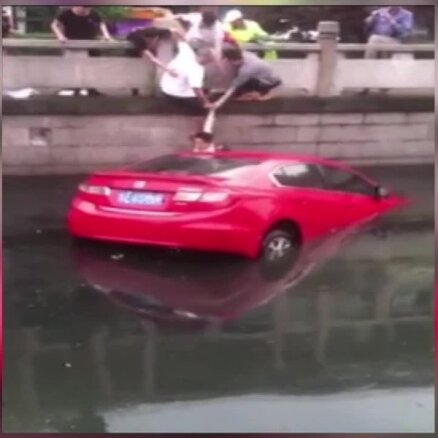 Video: Sievieti Ķīnā pēdējā brīdī izglābj no slīkstošas automašīnas