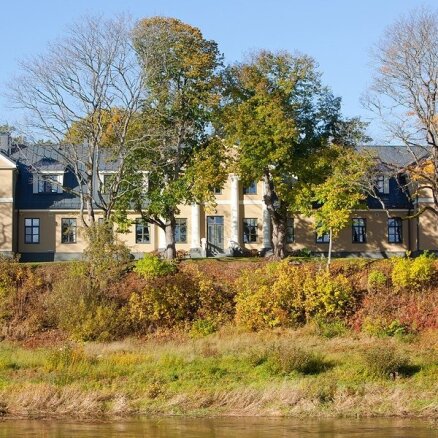 Skrundas muiža gleznainajā Ventas upes krastā ar labo mājas gariņu
