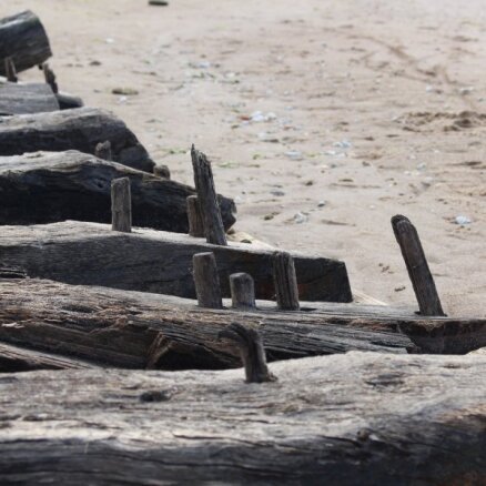 Daugavgrīvas pludmalē izskalotais senā kuģa vraka fragments nogādāts krastā