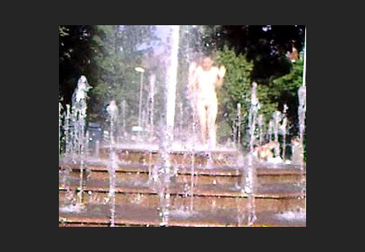 Голая девушка купается в фонтане