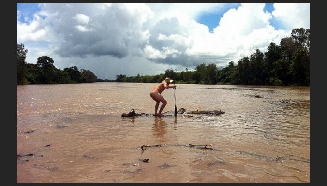 Pliks austrālietis peld pa upi ar krokodiliem