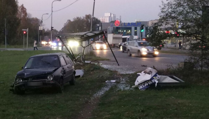 ФОТО: В Риге машина снесла остановку, пострадал подросток