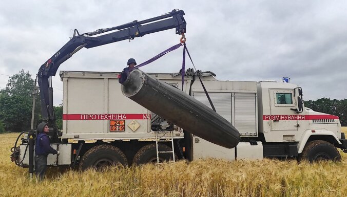 украинские спасатели поднимают фрагмент ракеты поле с зерно Николаев
