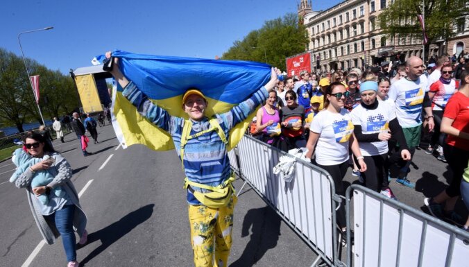 Foto: Smaidīga tauta ar dažādiem karogiem pieveic Rīgas maratonu